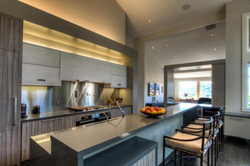 Modern Kitchen design includes light grey cabinets and dark grey countertops, bar and bar seating.