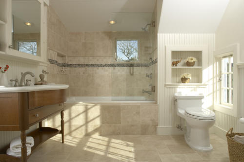 Airy and spacious, this bathroom showcases beadboard on the walls and exquisite wooden vanity for the sink.