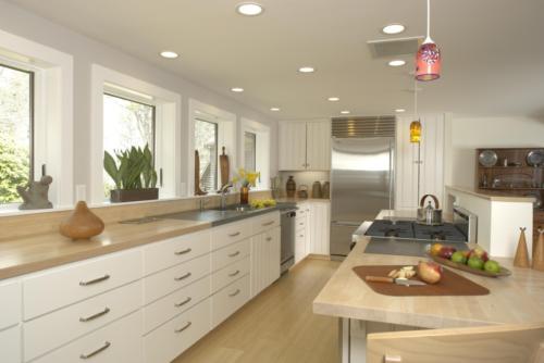 Luxury Kitchen with white cabinets and red glass pendant light fixtures.