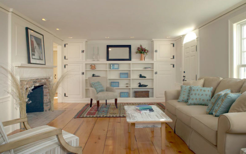 Living room with wide plank flooring, fireplace and built-ins.