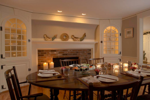 Dining room with oversized fireplace and glass front built-ings.