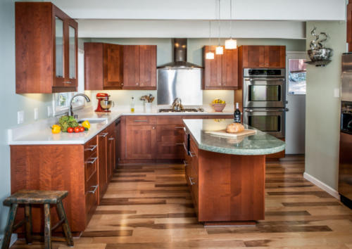 U-Shaped kitchen with granite topped island and stainless steel appliances and stainless hood over stove.